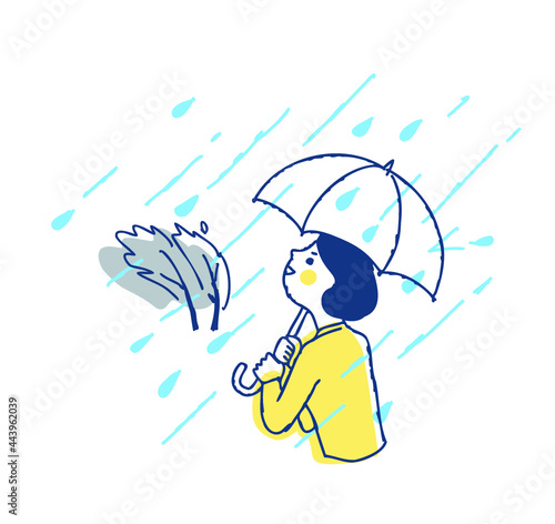 豪雨の中傘をさして歩く女性
