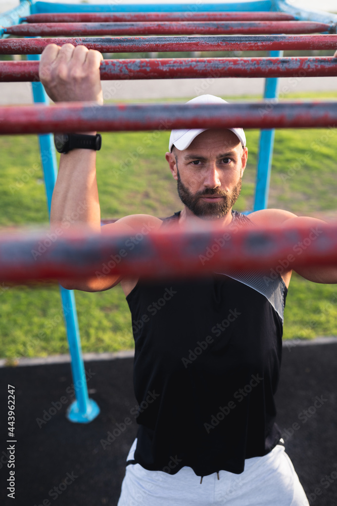 Obraz premium Fitness Model doing pull ups on Monkey Bars