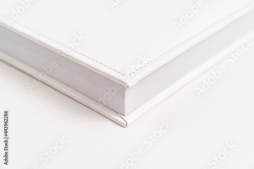 corner of white book in leather binding. photobooks and albums.