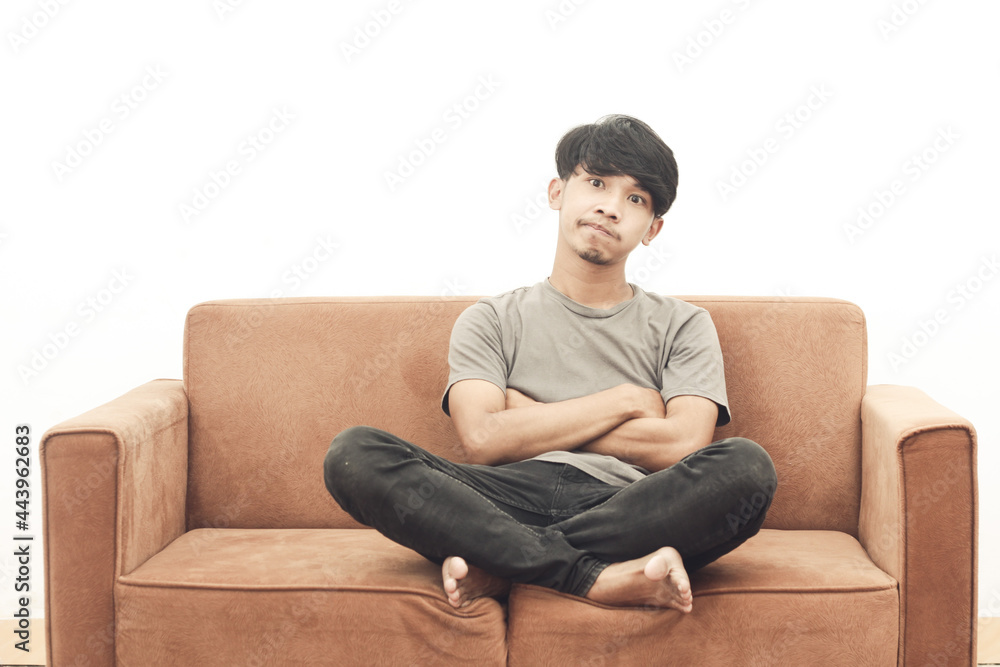 portrait of asian youth wearing gray t-shirt sitting on the sofa thinking portrait of asian youth wearing gray t-shirt sitting on the sofa thinking