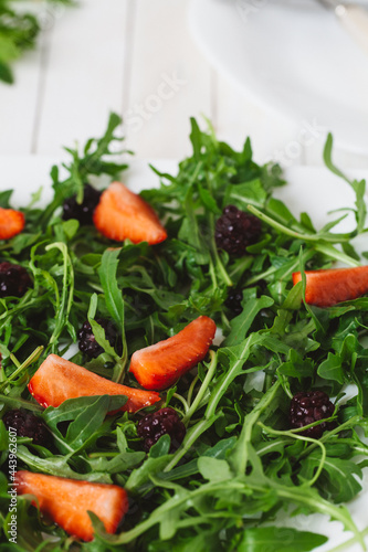 Fresh salad with rucola and  blackberry, close up..