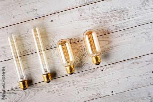 Classic Edison light bulb on wooden background top view, retro style. Flat lay.