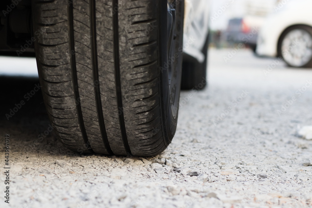 Zoom at car wheel tire on gravel stone street Zoom at car wheel tire on gravel stone street