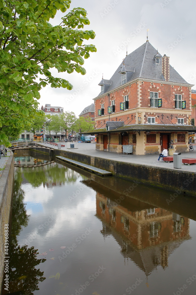 Naklejka premium Reflections of de Waag, historic public weigh house (dated from 1598), located on Waagplein square in Leeuwarden, Friesland, Netherlands