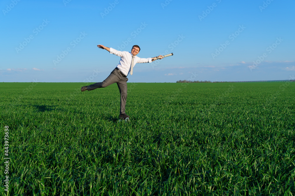 businessman poses with a spyglass in a green field, he looks an idea or something, business concept, green grass and blue sky as background businessman poses with a spyglass in a green field, he looks an idea or something, business concept, green grass and blue sky as background