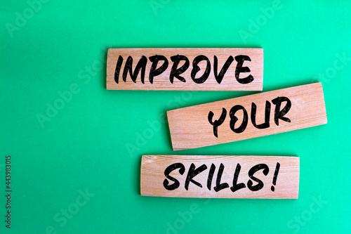 Improve Your Skills words made on wooden building blocks green background.