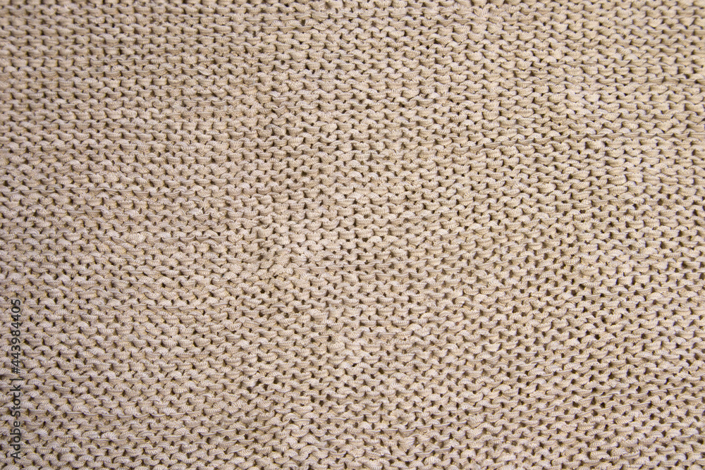 Abstract knitted background. Light grey or beige woolen sweater texture. Close up picture of knitted pattern Abstract knitted background. Light grey or beige woolen sweater texture. Close up picture of knitted pattern