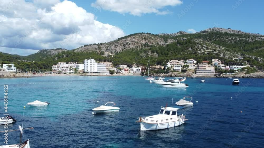 Drone flying closely over smaller boats and yachts towards a hotel with beach and mountain landscape in Mallorca spain! Drone flying closely over smaller boats and yachts towards a hotel with beach and mountain landscape in Mallorca spain!