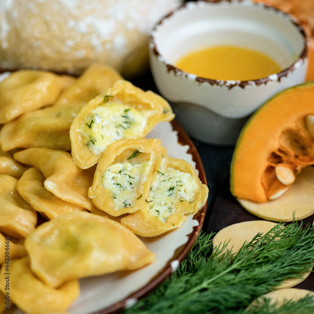 Boiled pumpkin dumplings with egg and dill filling, cross section. Convenience Food. Square format. Soft focus. Close-up shot.