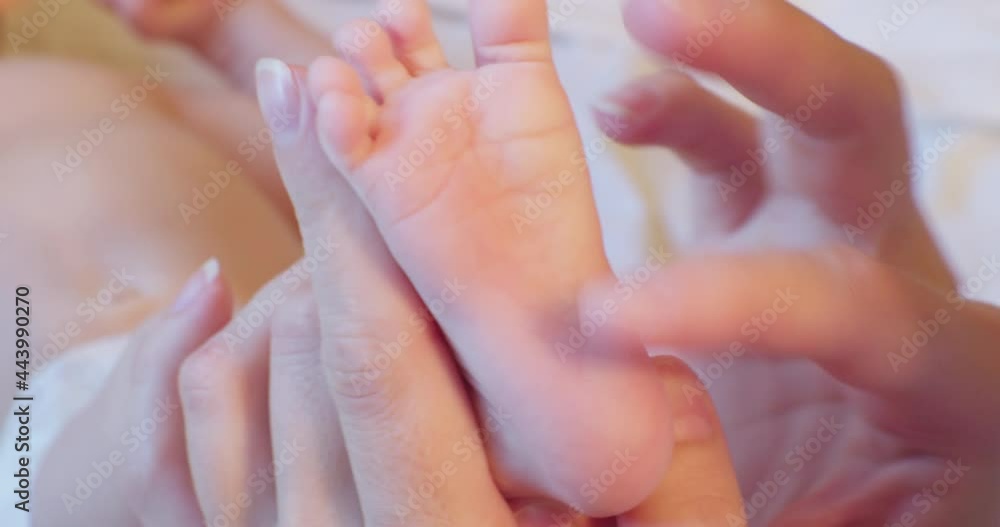 happy motherhood and family happiness.caring mother's hands gently massage the little feet of the baby.close-up.shallow depth of field. happy motherhood and family happiness.caring mother's hands gently massage the little feet of the baby.close-up.shallow depth of field.