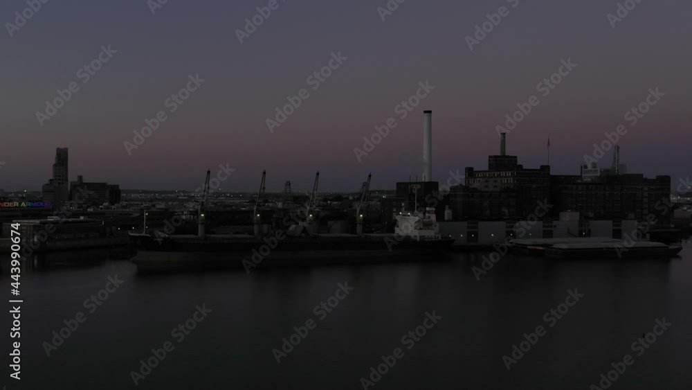 Aerial rise at early morning blue hour over an industrial ship and factory in Baltimore Maryland harbor on the Patapsco river Aerial rise at early morning blue hour over an industrial ship and factory in Baltimore Maryland harbor on the Patapsco river