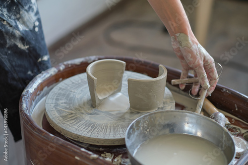Female Potter creating a earthen jar on a Potter's wheel © yavdat