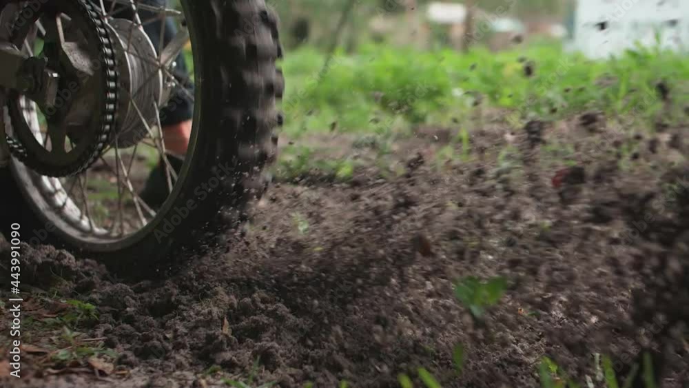A dirt bike rider kicking up dirt while driving past. A dirt bike rider kicking up dirt while driving past.