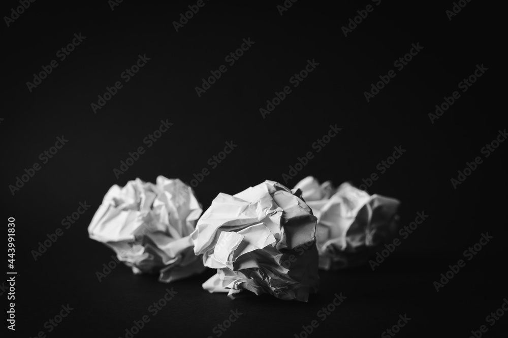 Three Crumpled white paper ball on black background.