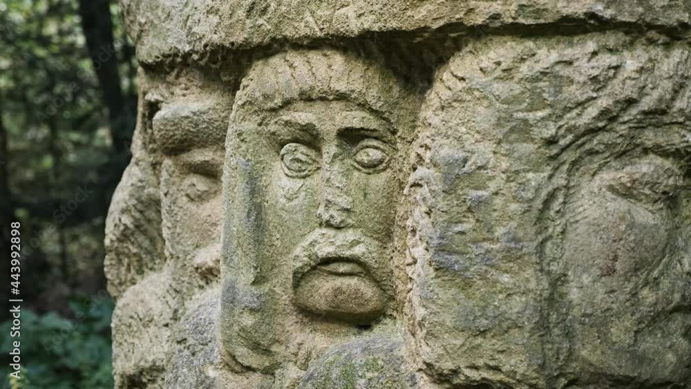 Carved sculpture of human faces in stone in the Carpathian forest Carved sculpture of human faces in stone in the Carpathian forest