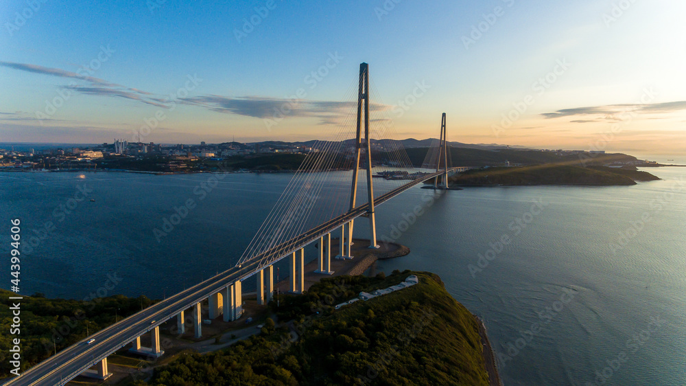Russian bridge across the Eastern Bosphorus Strait in Vladivostok. View from above. Russian bridge against the background of a beautiful sunrise.