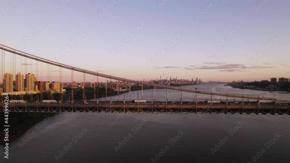 Beautiful evening aerial of trucks and cars on bridge with New York City skyline