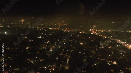 An aerial view of the 2021 Fourth of July fireworks set off by the locals on Long Island, NY. The drone camera truck right high over the suburban neighborhood as the fireworks go off below.