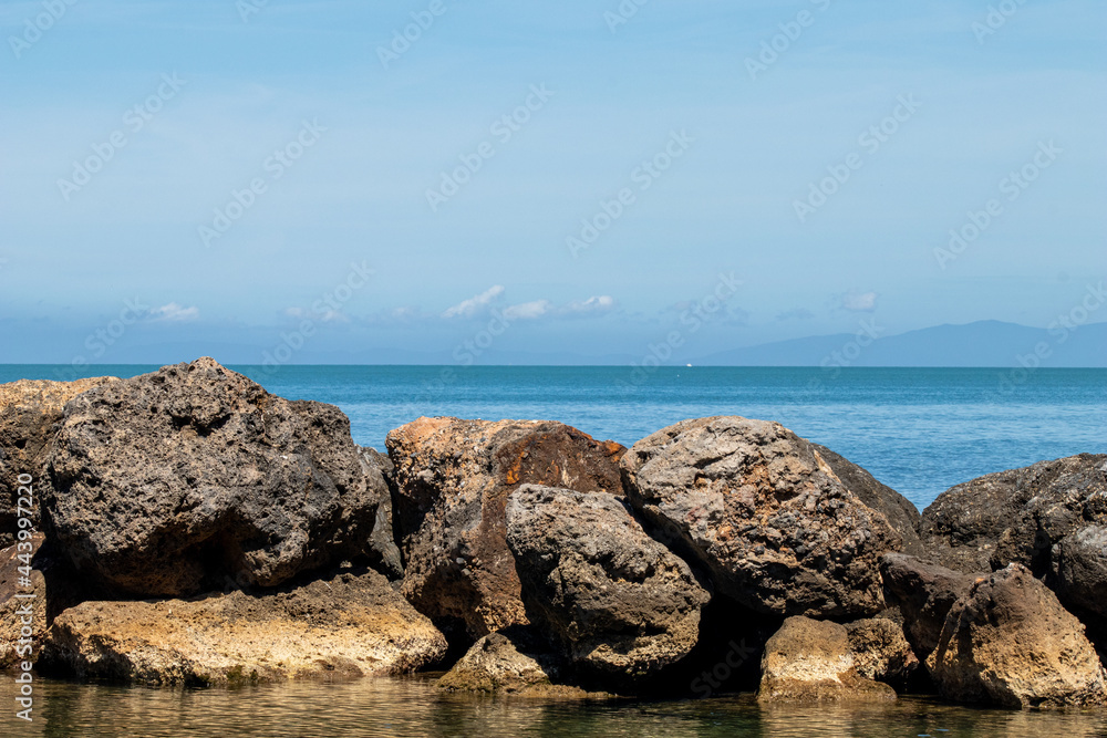 Sea and rock background. Rock and blue sea with clear sky. Seaside travel destination background image. Clear blue sea and blue sky in summertime Sea and rock background. Rock and blue sea with clear sky. Seaside travel destination background image. Clear blue sea and blue sky in summertime