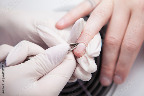Close up of professional manicurist using nippers while working