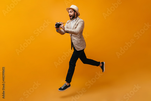 Happy man in stylish outfit jumping and taking photos © Look!