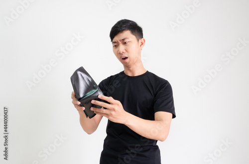 Asian man black shirt look at wallet in hand feel shock at face on white isolated,Poor man find money in wallet concept