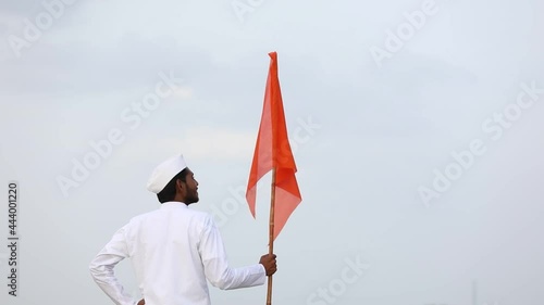 Young indian man (pilgrim) in traditional wear and waving religious flag. photo