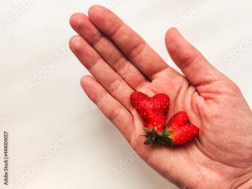 strawberry in the shape of a heart on the palm 