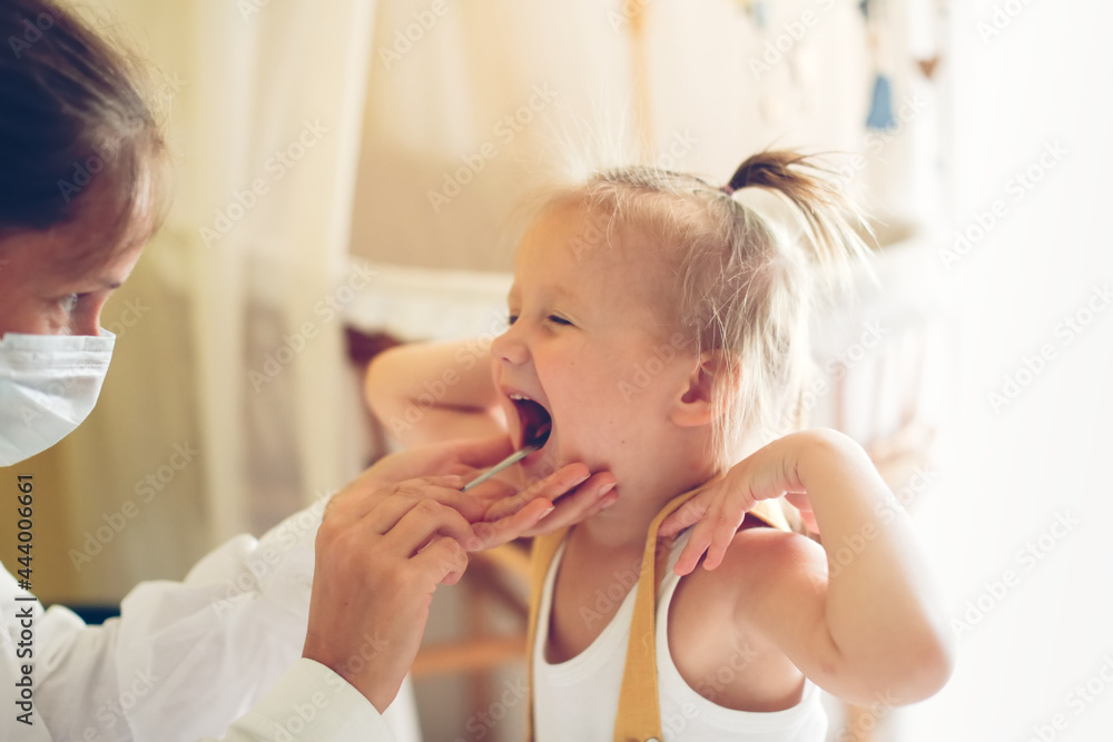 funny little girl Toddler shows her throat to nurse in mask and white coat, calling doctor at home, patronage. Examination of pediatrician in a real interior,concept of medicine and disease prevention funny little girl Toddler shows her throat to nurse in mask and white coat, calling doctor at home, patronage. Examination of pediatrician in a real interior,concept of medicine and disease prevention
