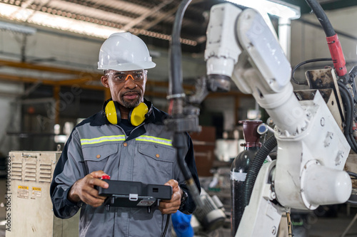 Obraz na płótnie Robotics control engineers setting and maintain spare parts of industrial robot arm controller in production plant factory w salonie