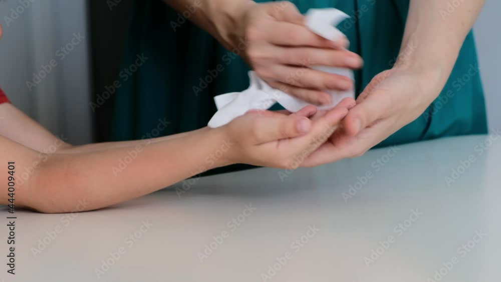 Woman using wet antiseptic wipe to clean child's hands, protect from virus, pandemia, covid. Close up Woman using wet antiseptic wipe to clean child's hands, protect from virus, pandemia, covid. Close up