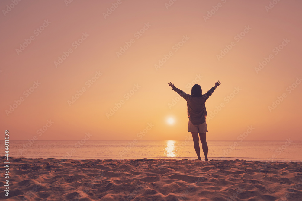 Fototapeta premium Copy space of woman rise hand up on sunset sky at beach and island background.