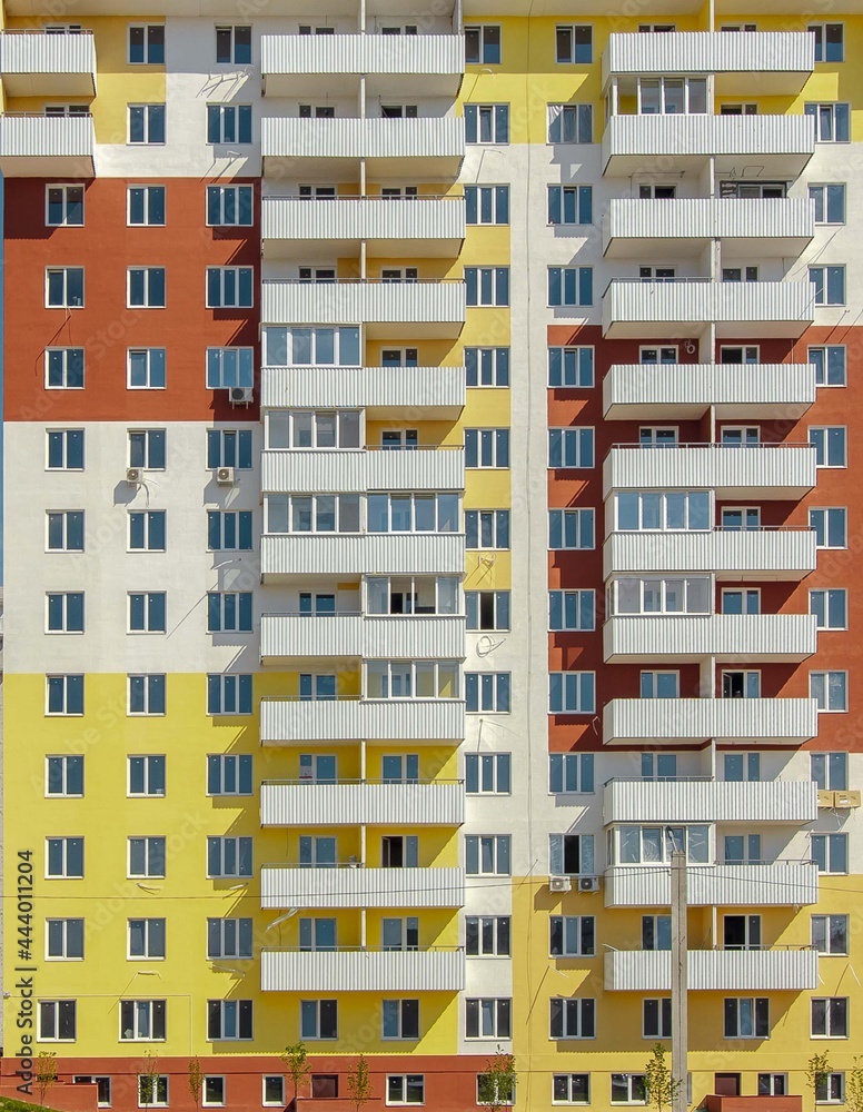 Facade of a modern yellow multi-storey residential building . High quality photo
