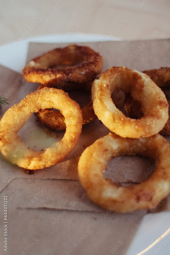 Close-up of onion rings in batter. Fried vegetables at a fast food restaurant. Vegetarian cuisine in a cafe. Meal for those who do not eat meat Close-up of onion rings in batter. Fried vegetables at a fast food restaurant. Vegetarian cuisine in a cafe. Meal for those who do not eat meat