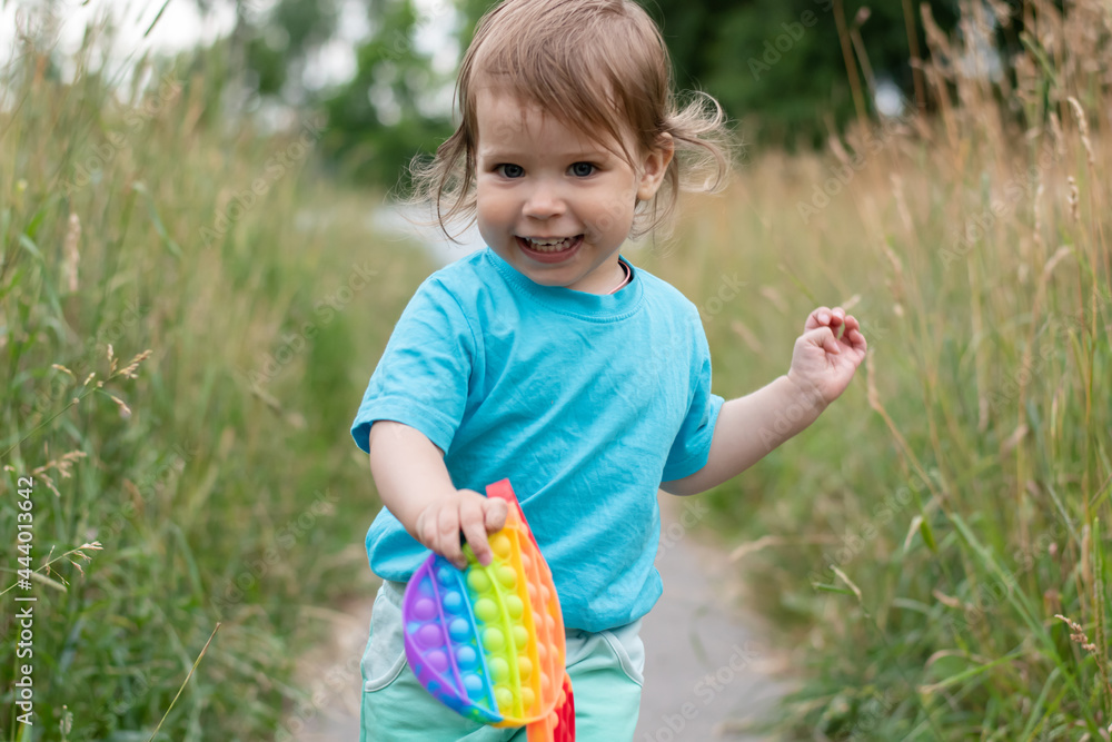 Happy baby running among the grass with a toy in his hands. Happy baby running among the grass with a toy in his hands.