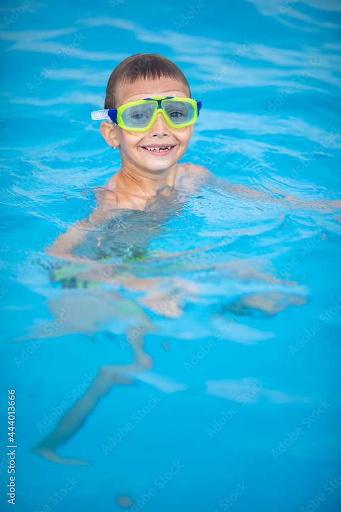Naklejka premium Cute little boy in a swimming pool
