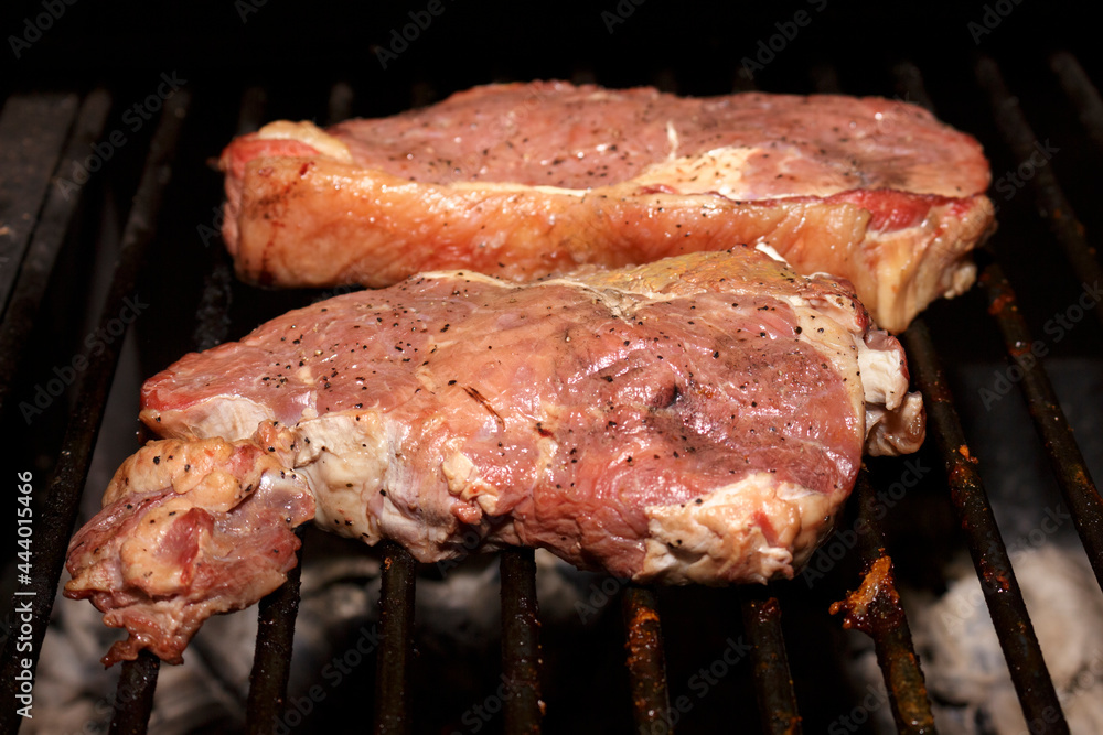 Tasty seasoned ancho steaks freshly placed on the barbecue. Rump meat. Food photography.