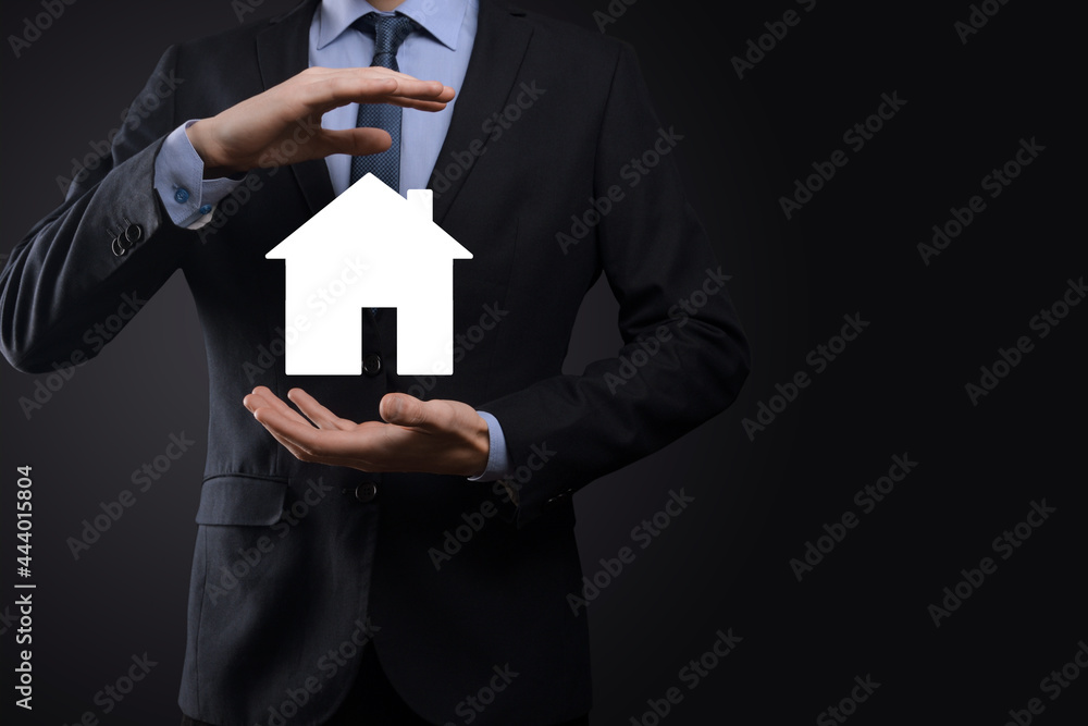 Businessman male hand holding house icon on blue background. Property insurance and security concept.Real estate concept.Banner with copy space. Businessman male hand holding house icon on blue background. Property insurance and security concept.Real estate concept.Banner with copy space.