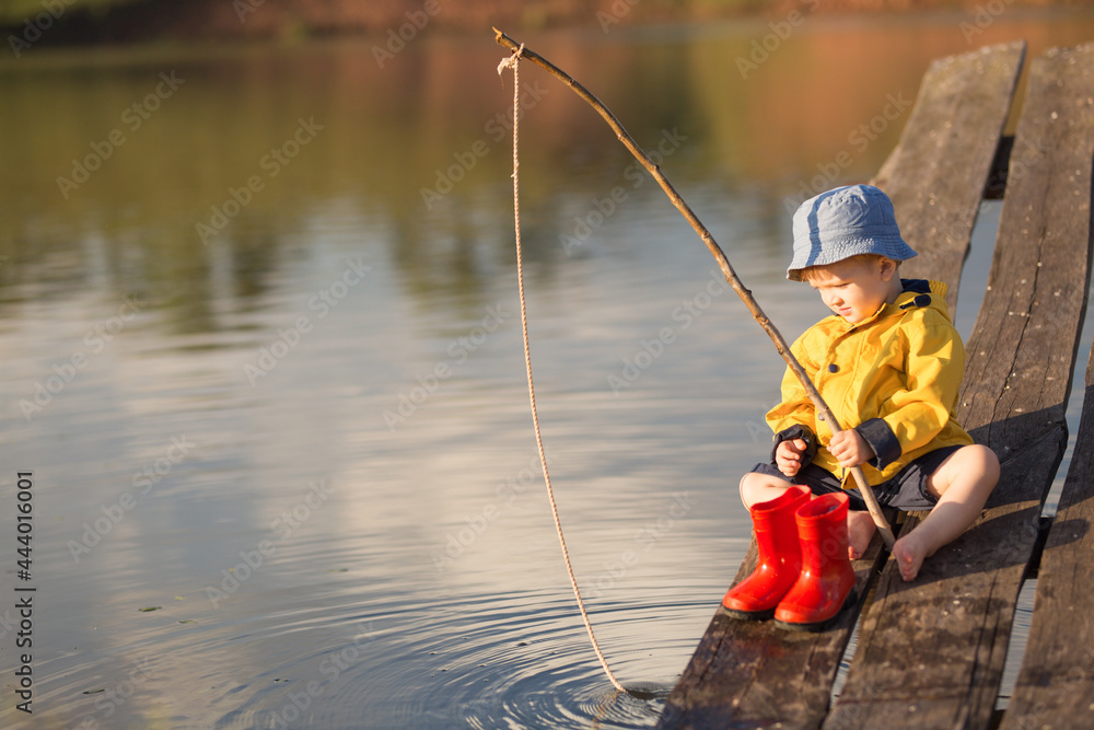 Little Boy Catching a Fish from wooden dock Little Boy Catching a Fish from wooden dock