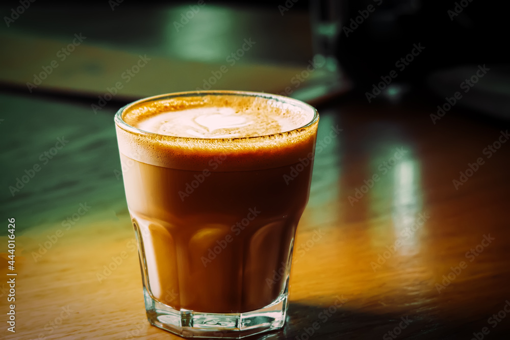 Flat-white coffee in small glass served on wooden tabletop. Flat-white coffee in small glass served on wooden tabletop.