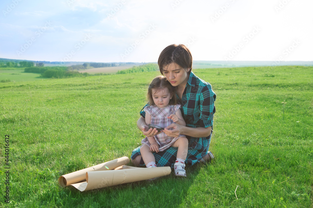 A beautiful young mother with her children looks at a map of the world and decide where to go on trip. A beautiful young mother with her children looks at a map of the world and decide where to go on trip.