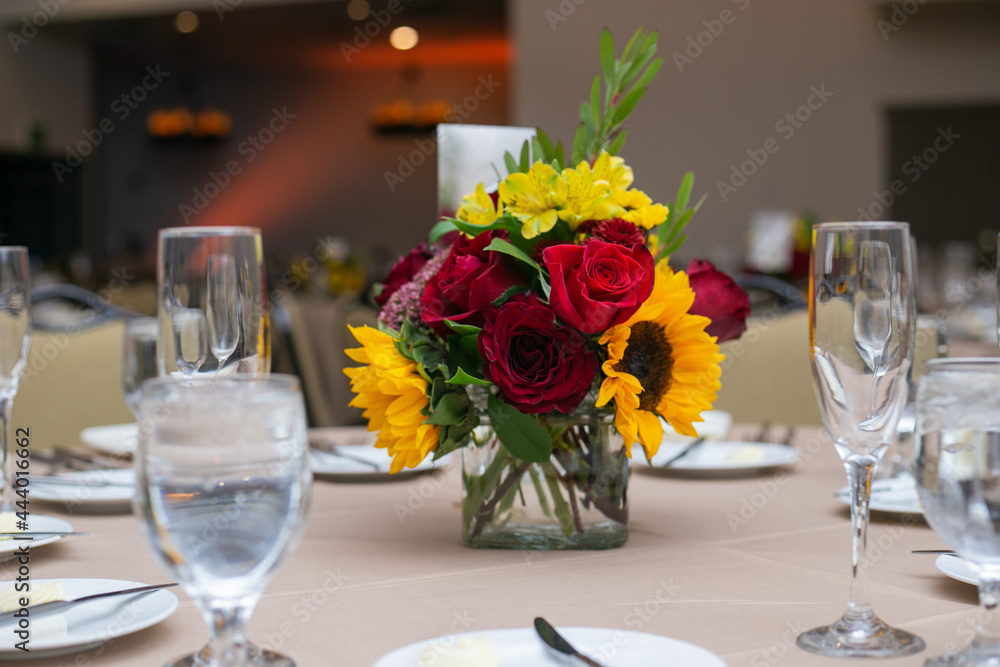 sunflowers and red flowers in small vase on a table for wedding or reception event sunflowers and red flowers in small vase on a table for wedding or reception event