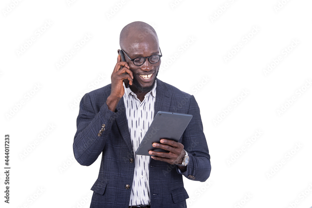 Close-up of a young businessman talking on the cellphone, smiling.a young businessman in a gray suit standing on a white background talking on the cellphone smiling while holding a tablet. Close-up of a young businessman talking on the cellphone, smiling.a young businessman in a gray suit standing on a white background talking on the cellphone smiling while holding a tablet.