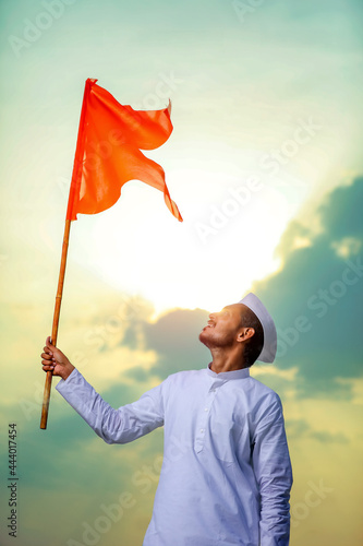 Young indian man (pilgrim) in traditional wear and waving religious flag. photo