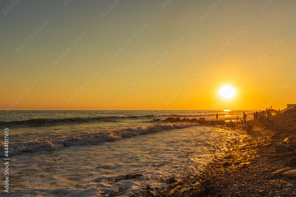 Fototapeta premium Dark blue waves against the beautiful orange sunset at the Black Sea, Anapa, Russia