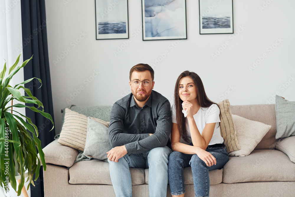 Obraz premium Couple sitting together on the sofa in domestic room