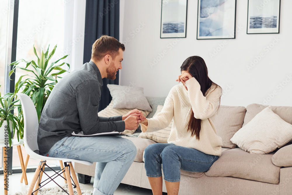 Young woman at a reception at a psychologist. Crying and talking about problems Young woman at a reception at a psychologist. Crying and talking about problems