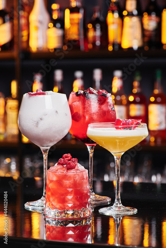 Four different fruit cocktails in beautiful glasses on the bar in a nightclub. Space for text. High quality photo