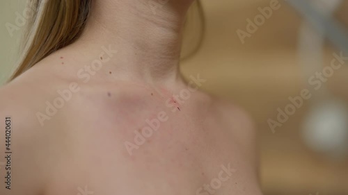 Male hand marking female chest with pen indoors. Unrecognizable doctor putting spots on skin of naked young woman preparing for aesthetic surgery on breast augmentation photo