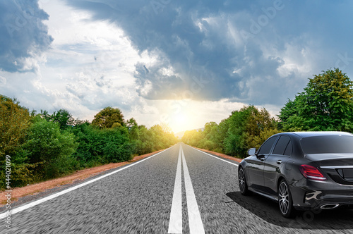 Car moves on the road on a summer day.